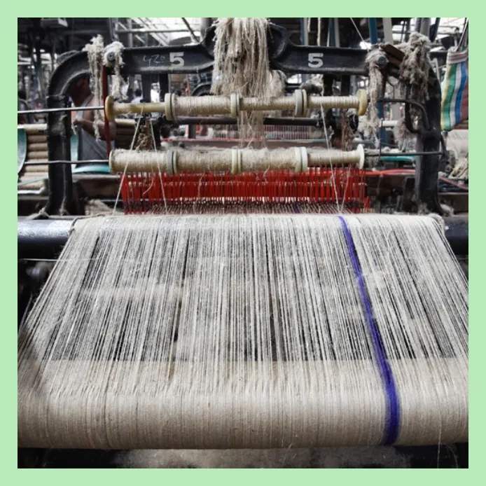 Close-up of jute threads on a weaving loom in textile factory
